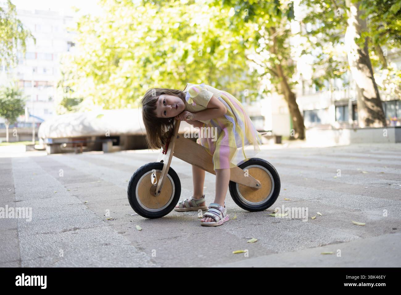 Un gamin jouant sur son vélo en bois. Banque D'Images