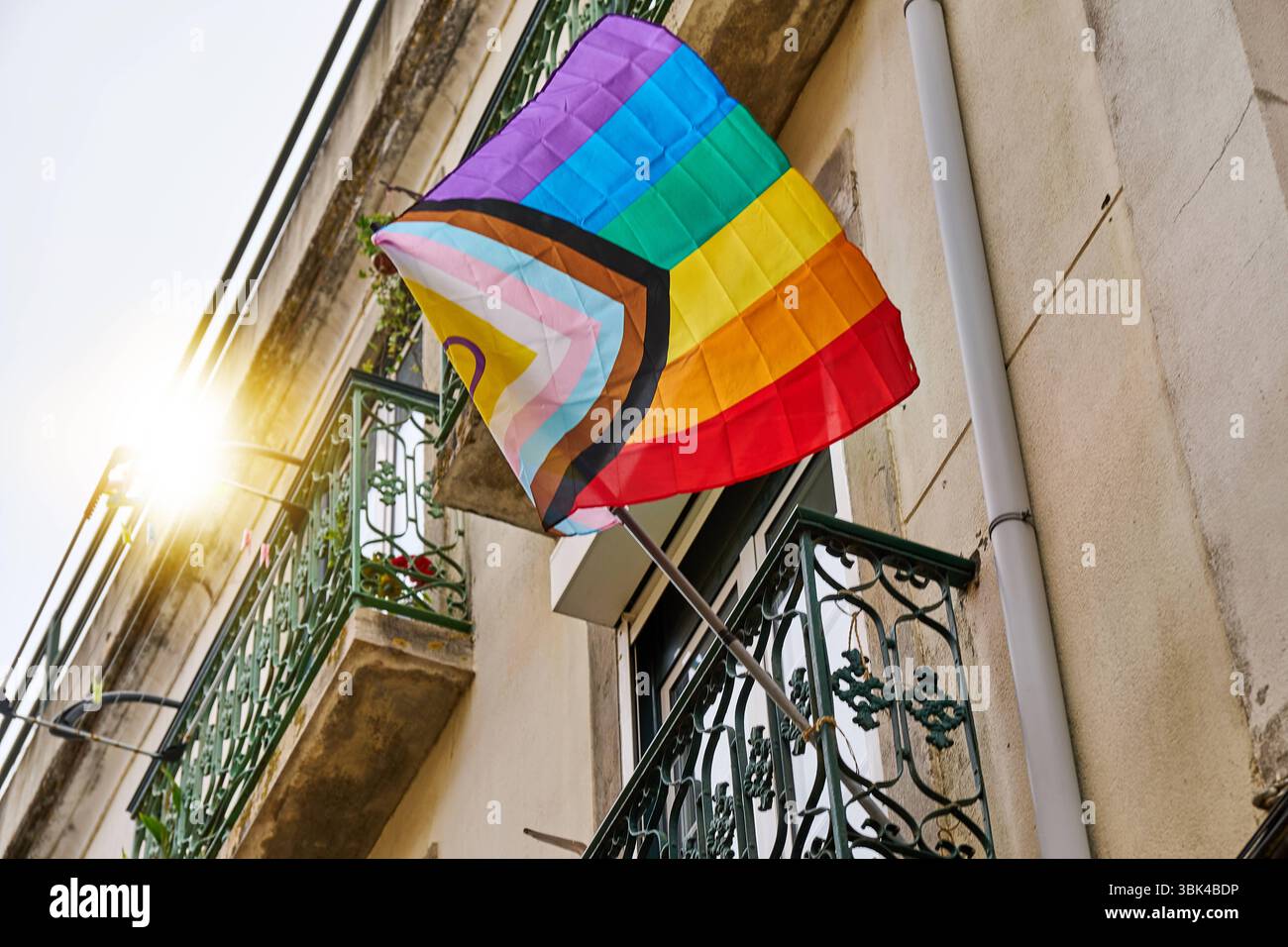 Lisbonne, Portugal - 10 juin 2025 : un drapeau coloré Progress Pride flotte sur un balcon, montrant un symbole fort de diversité, d'acceptation et de soutien à la communauté LGBTQIA dans l'espace urbain. *** Eine bunte Progress-Pride-Fahne weht an einem Balkon und zeigt ein Starkes Symbol für Vielfalt, Akzeptanz und Unterstützung der LGBTQIA Community im städtischen Raum. Banque D'Images