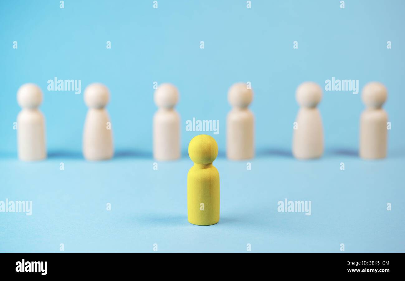 Démarquez-vous, de nouvelles idées et un leadership dans le concept d'affaires avec un chef de pion en bois jaune se démarquant et menant parmi les autres. Banque D'Images