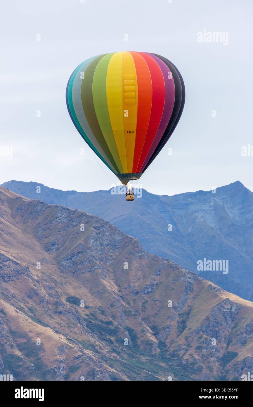 Une montgolfière survolant les crêtes montagneuses près de Queenstown, Otago, Nouvelle-Zélande Banque D'Images