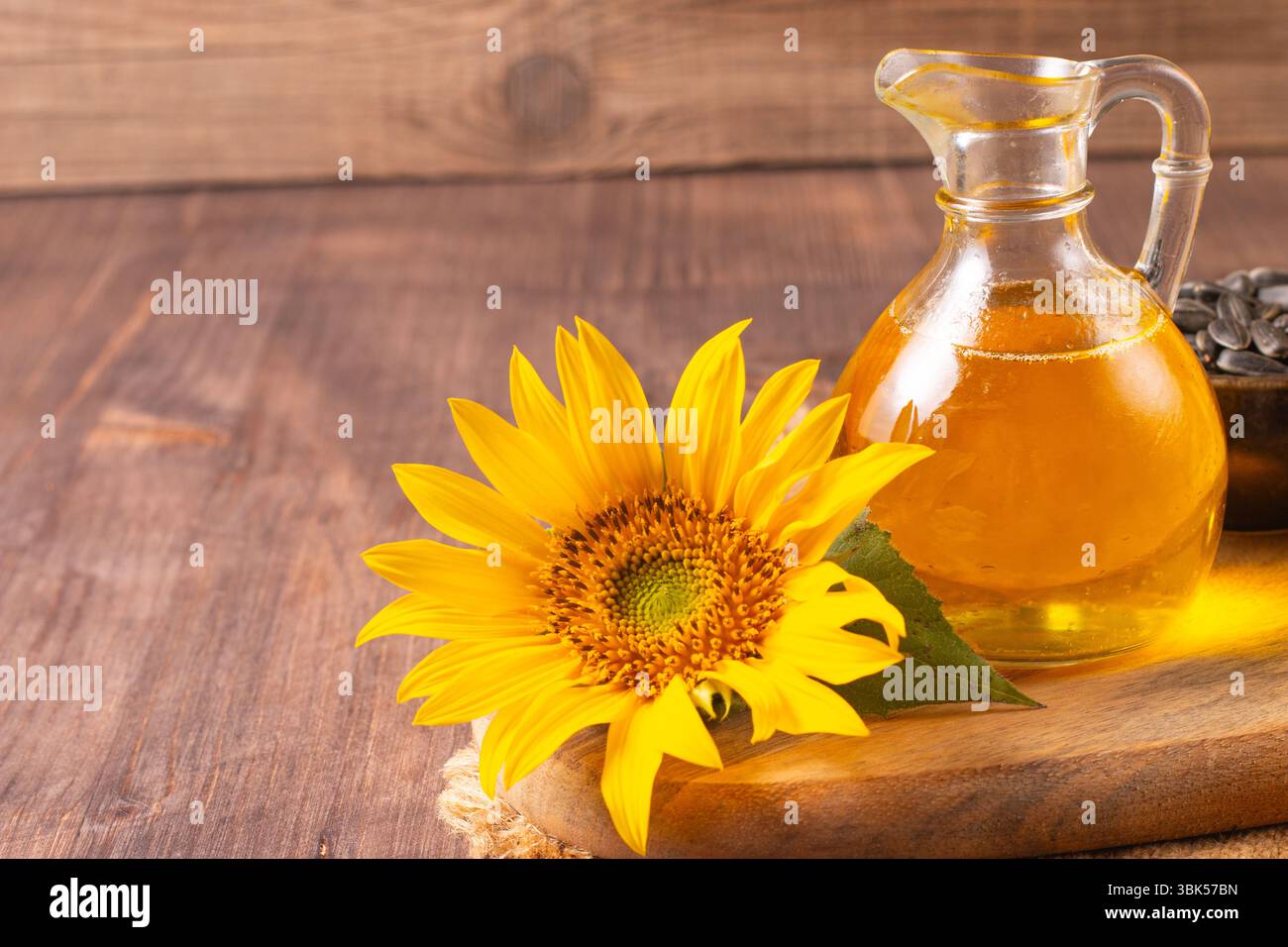 Huile de tournesol et graines de tournesol sur fond en bois rustique traditionnel. Concept alimentaire biologique et écologique. Aliments et graisses sains. Banque D'Images
