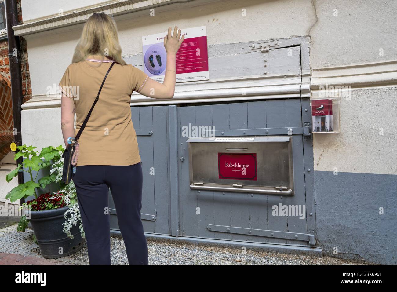 Femme agitant devant la trappe pour bébé Banque D'Images