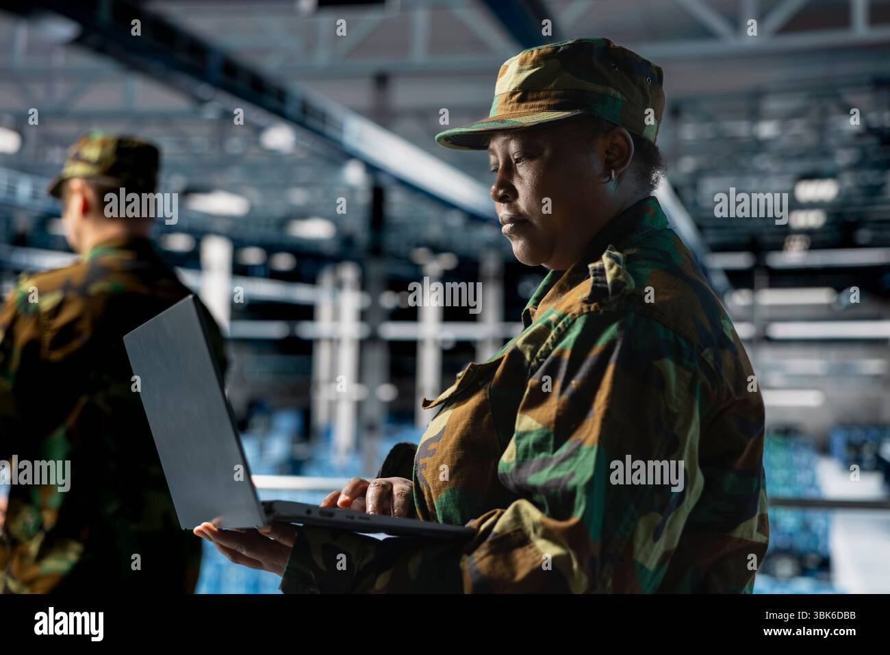Spécialiste INFORMATIQUE DE L'armée féminine dans le centre de données utilisant un ordinateur portable pour défendre les réseaux contre les cybermenaces. Administrateur du centre de commandement militaire utilisant un ordinateur portable pour identifier les intrusions potentielles ou les activités malveillantes Banque D'Images
