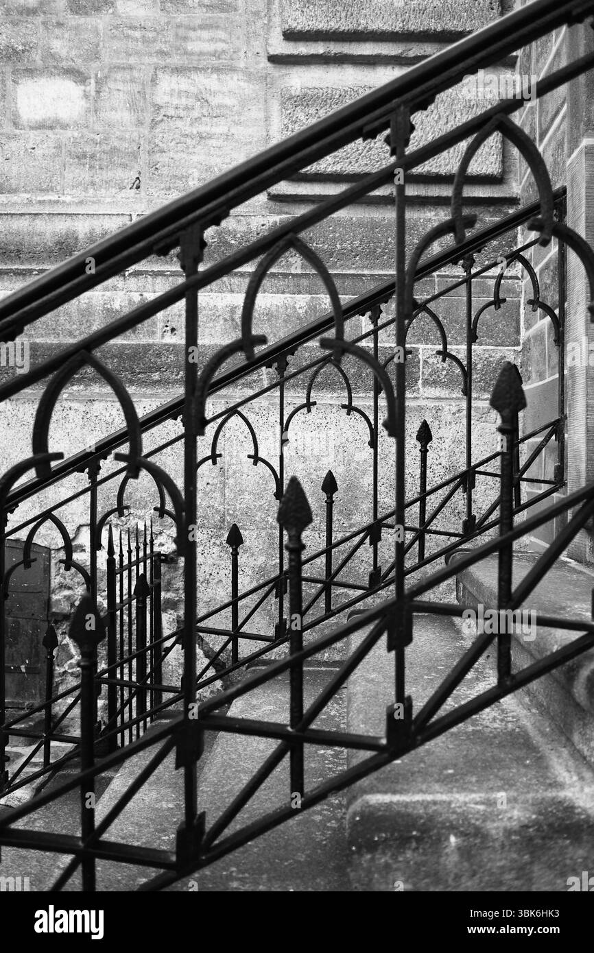Architecture : gros plan d'une rampe d'escalier décorative en fonte à l'entrée latérale d'un ancien bâtiment historique Banque D'Images