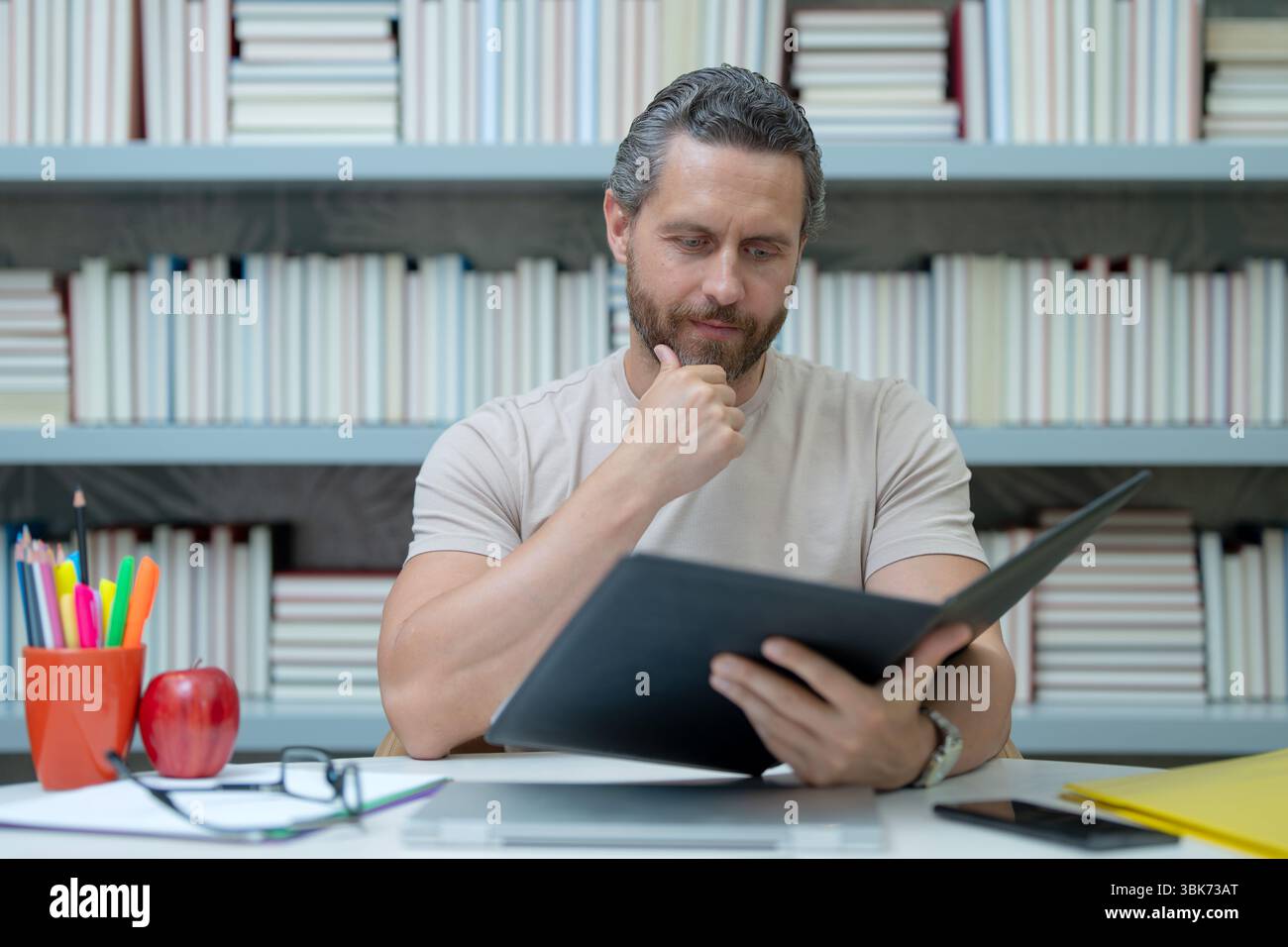 Portrait de professeur d'école avec livre dans la salle de classe. Beau professeur en classe. Journée des enseignants. Bon professeur. Tuteur en classe. Homme enseignant avec Banque D'Images
