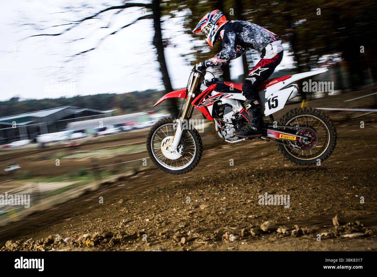 Plan d'action passionnant : pilote de motocross en plein air sur une piste de sable. Mouvement dynamique, parfait pour les projets sportifs et d'aventure. Banque D'Images