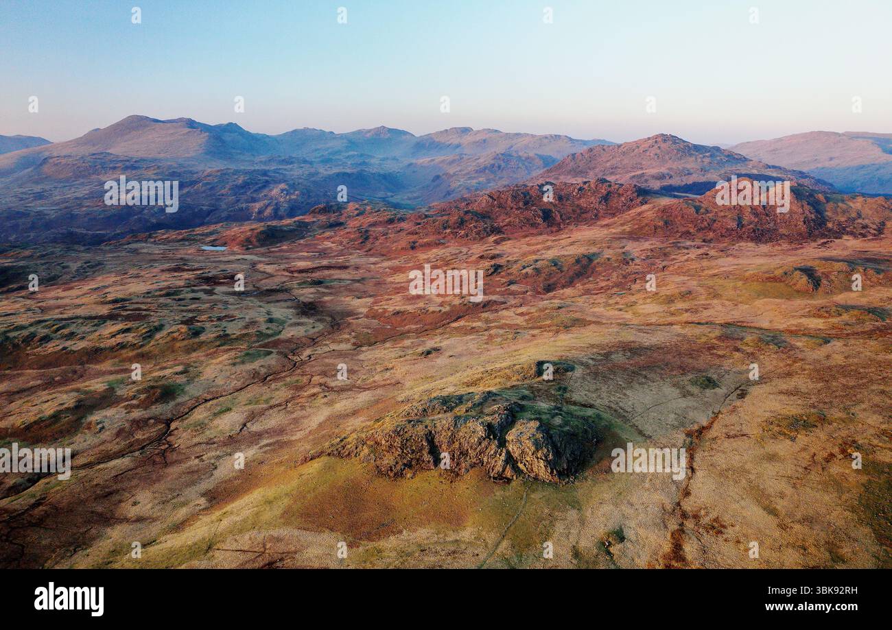 N. au-dessus d'Eskdale jusqu'au centre du Lake District, les puits de l-R SCA Fell, Esk Pike, Bow Fell, Crinkle Crags, Harter Fell de près de Devoke Water. Soirée de printemps Banque D'Images
