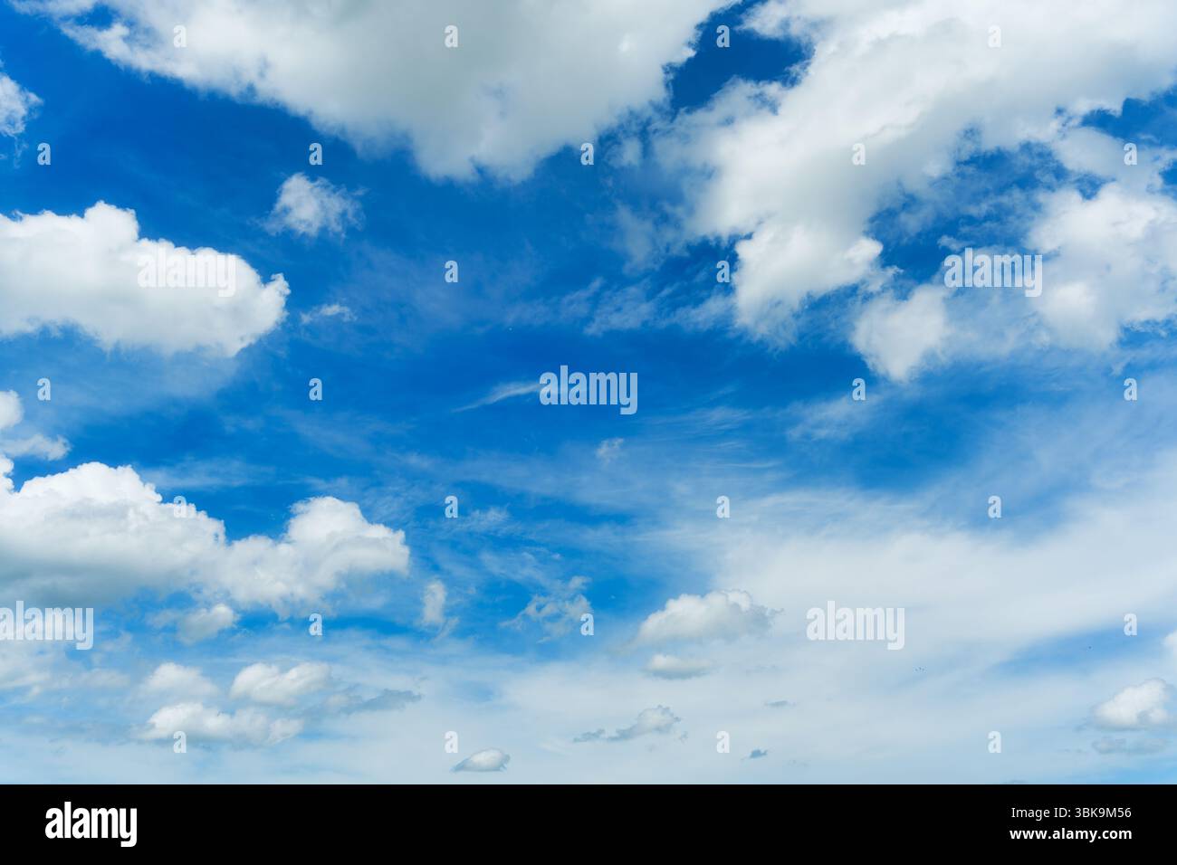 Ciel bleu vibrant avec des nuages blancs par temps clair Banque D'Images
