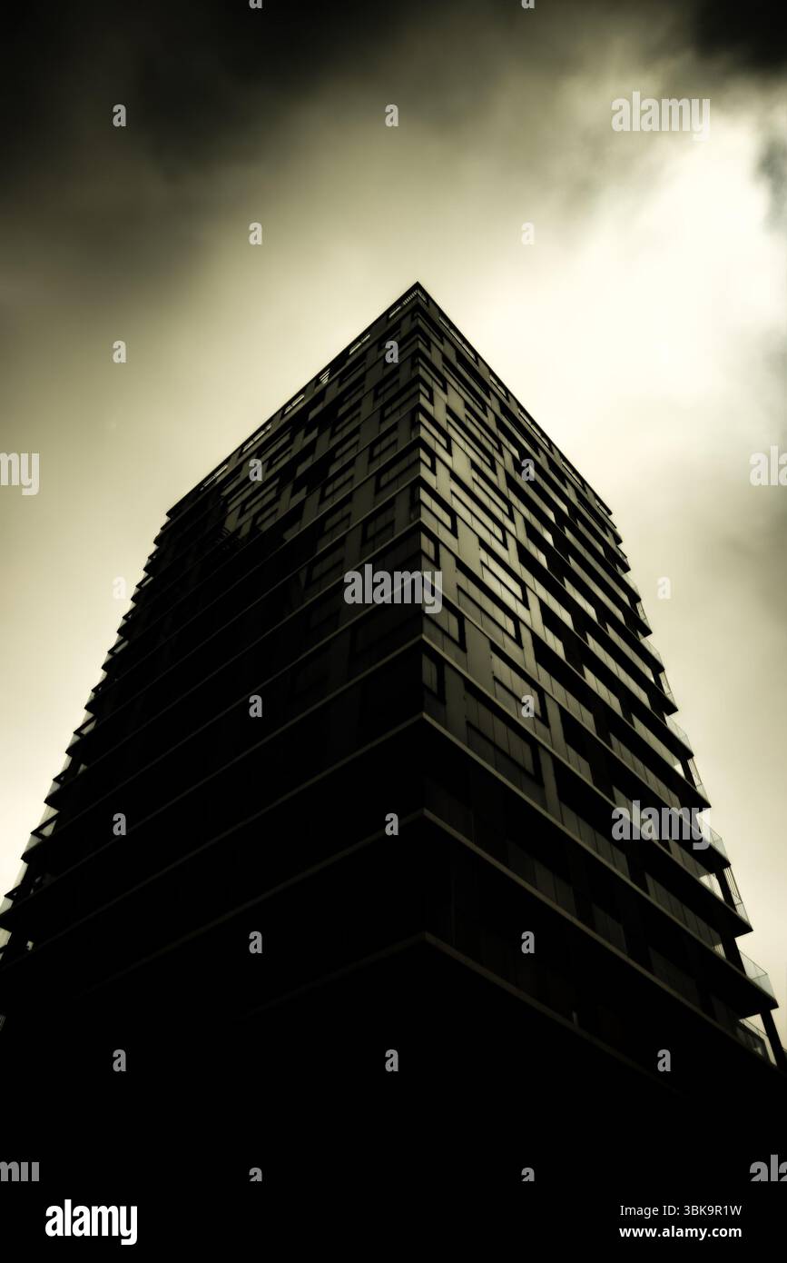 Bâtiment en verre avec prise de vue en angle de ciel nuageux foncé Banque D'Images