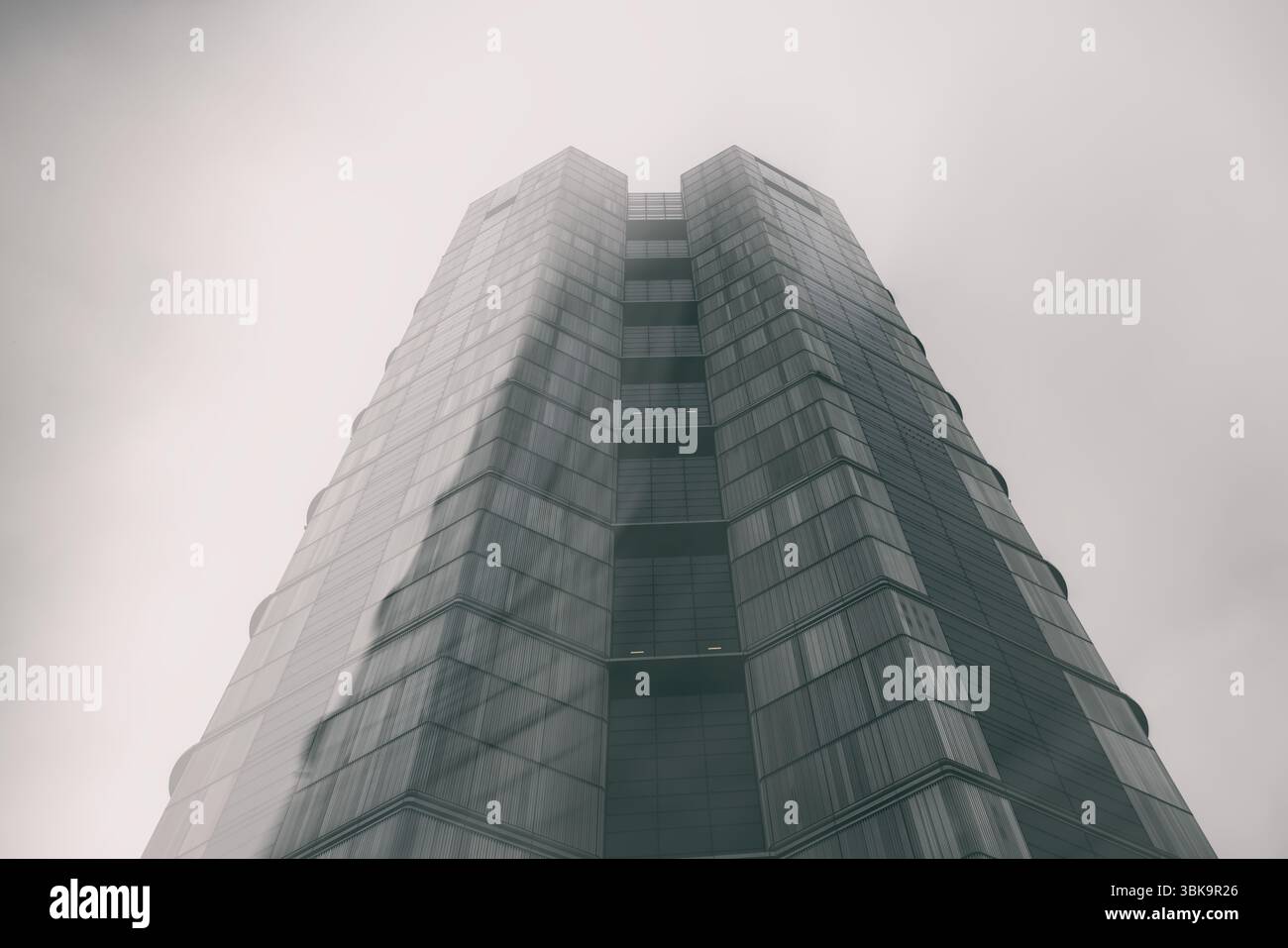 Bâtiment en verre avec prise de vue en angle de ciel nuageux foncé Banque D'Images