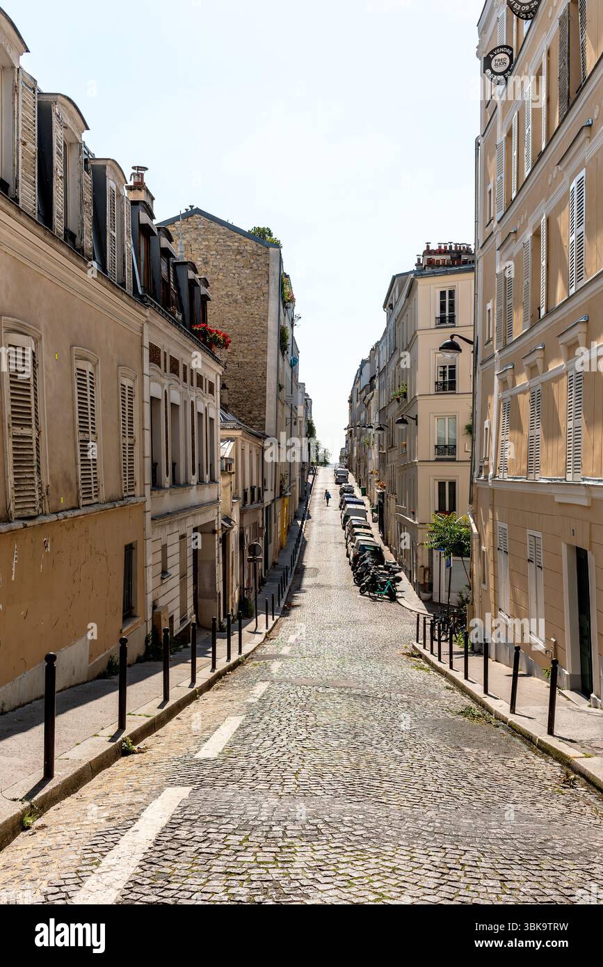 Paris, France, 06.16.2025. Une charmante rue pavée à Montmartre, le 18ème arrondissement de Paris par un beau jour de printemps Banque D'Images
