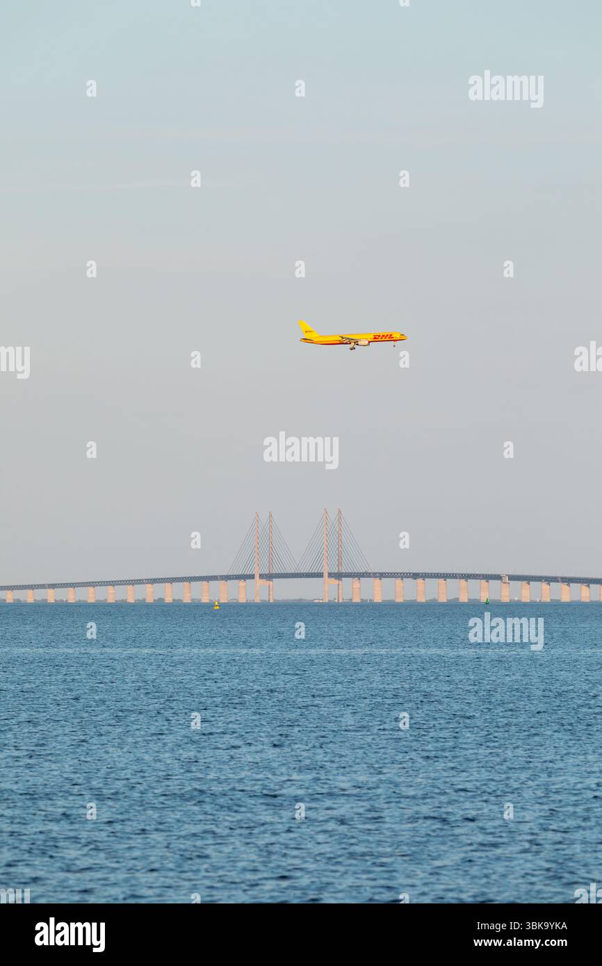 Avion cargo DHL en vol – DHL Express Air Freight survolant le pont Øresund, frontière entre le Danemark et la Suède Banque D'Images