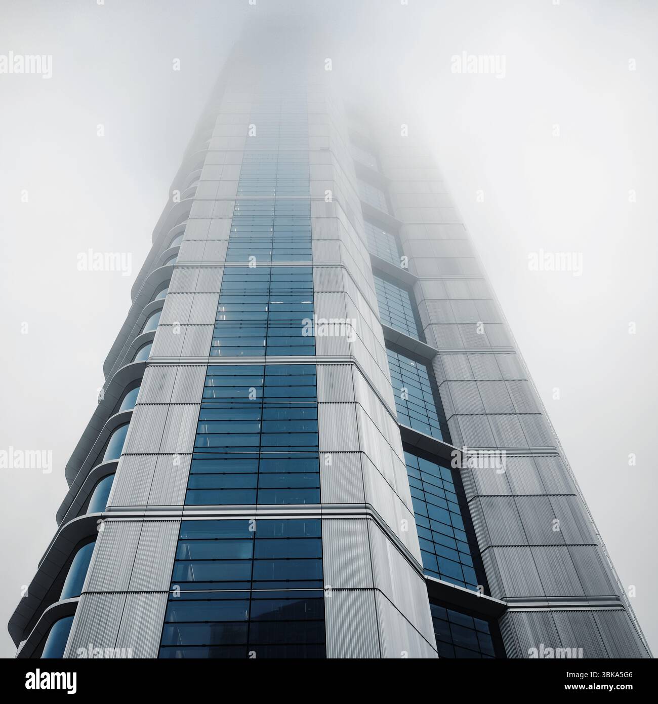 Bâtiment en verre avec prise de vue en angle de ciel nuageux foncé Banque D'Images