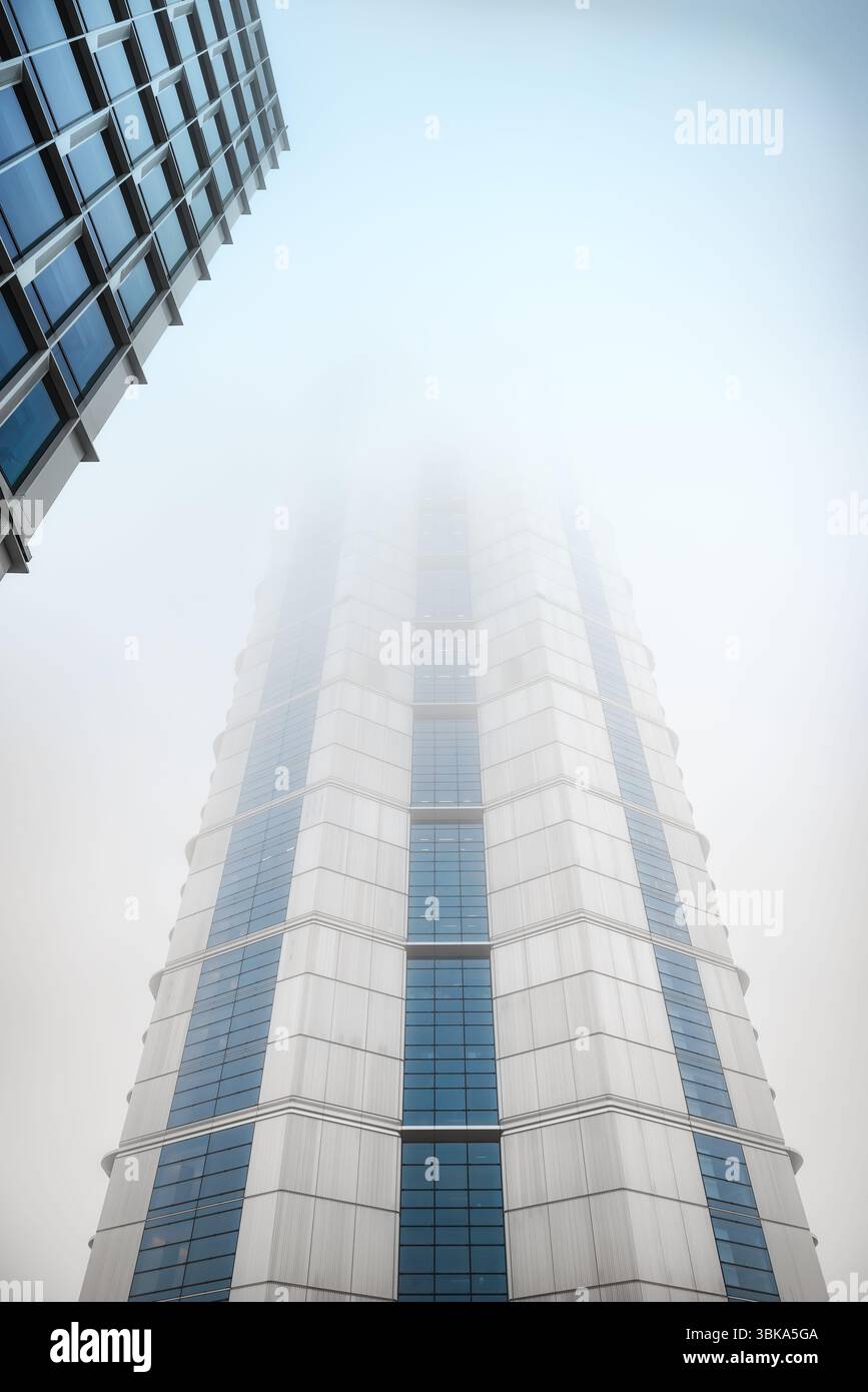 Bâtiment en verre avec prise de vue en angle de ciel nuageux foncé Banque D'Images