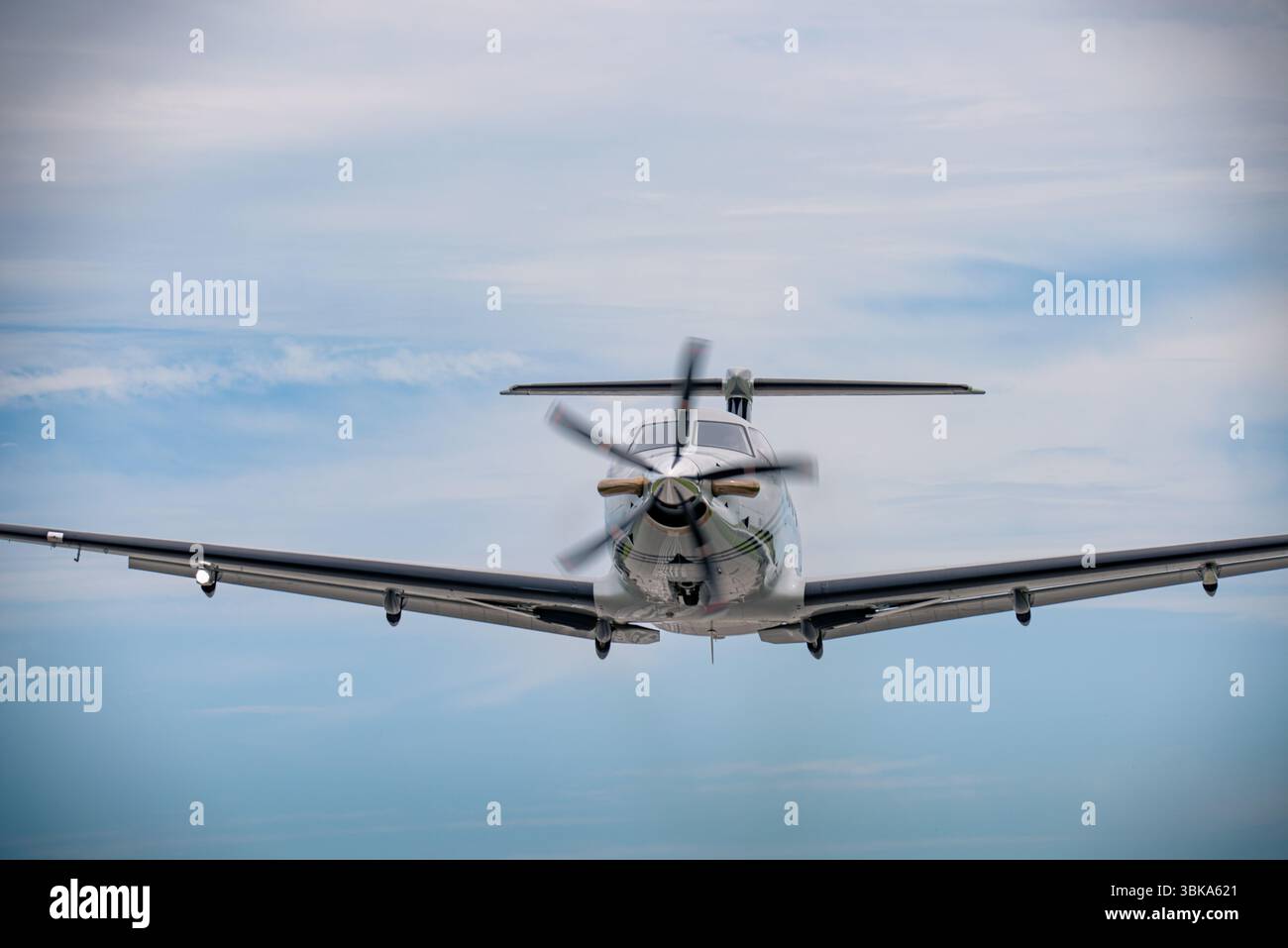Avion à turbopropulseurs prenant de l'altitude après le départ, centré dans le cadre avec train rentré et un ciel lisse en arrière-plan. Banque D'Images
