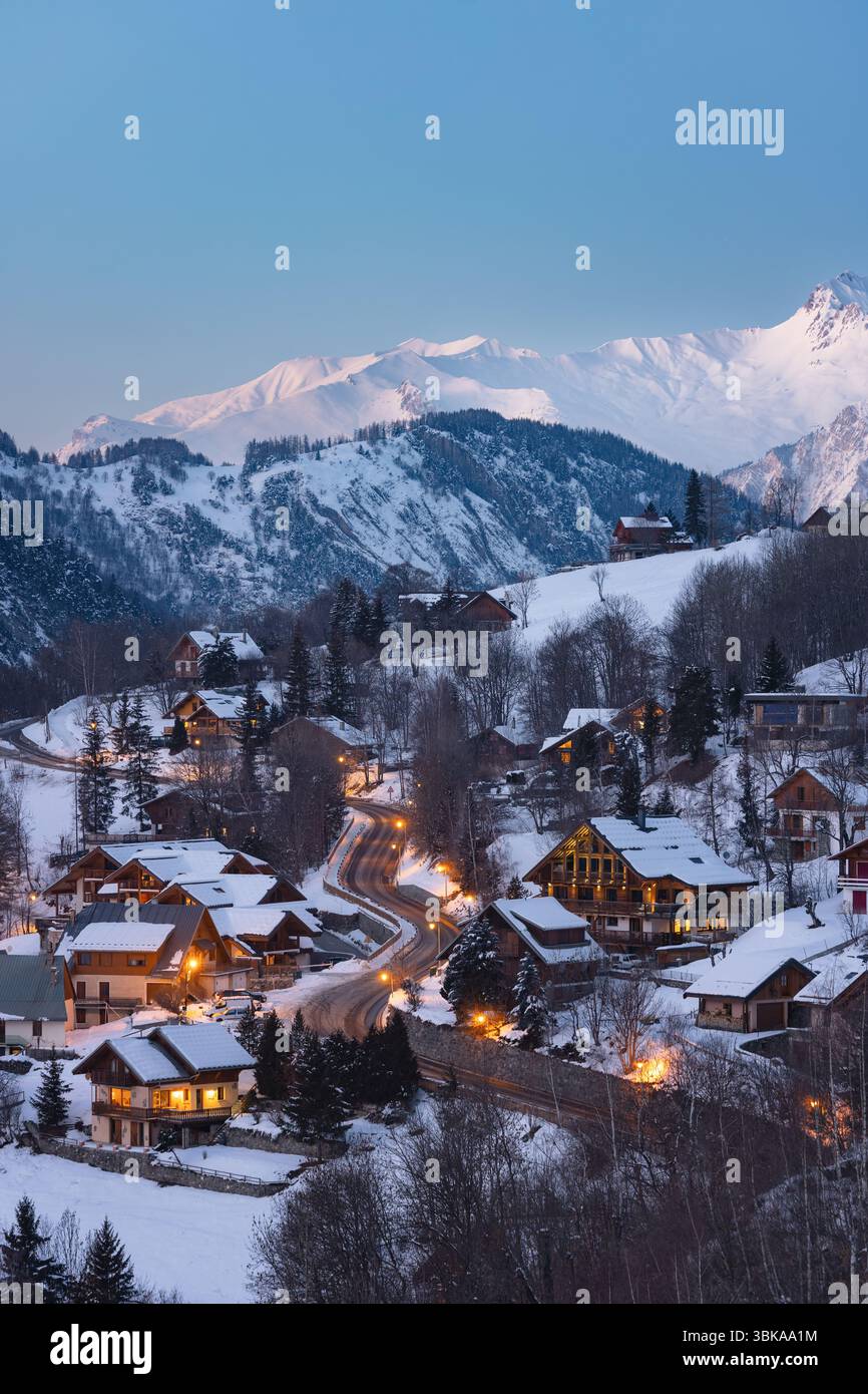 Village des Alpes françaises avec montagne enneigée et fond de routes éclairées Banque D'Images