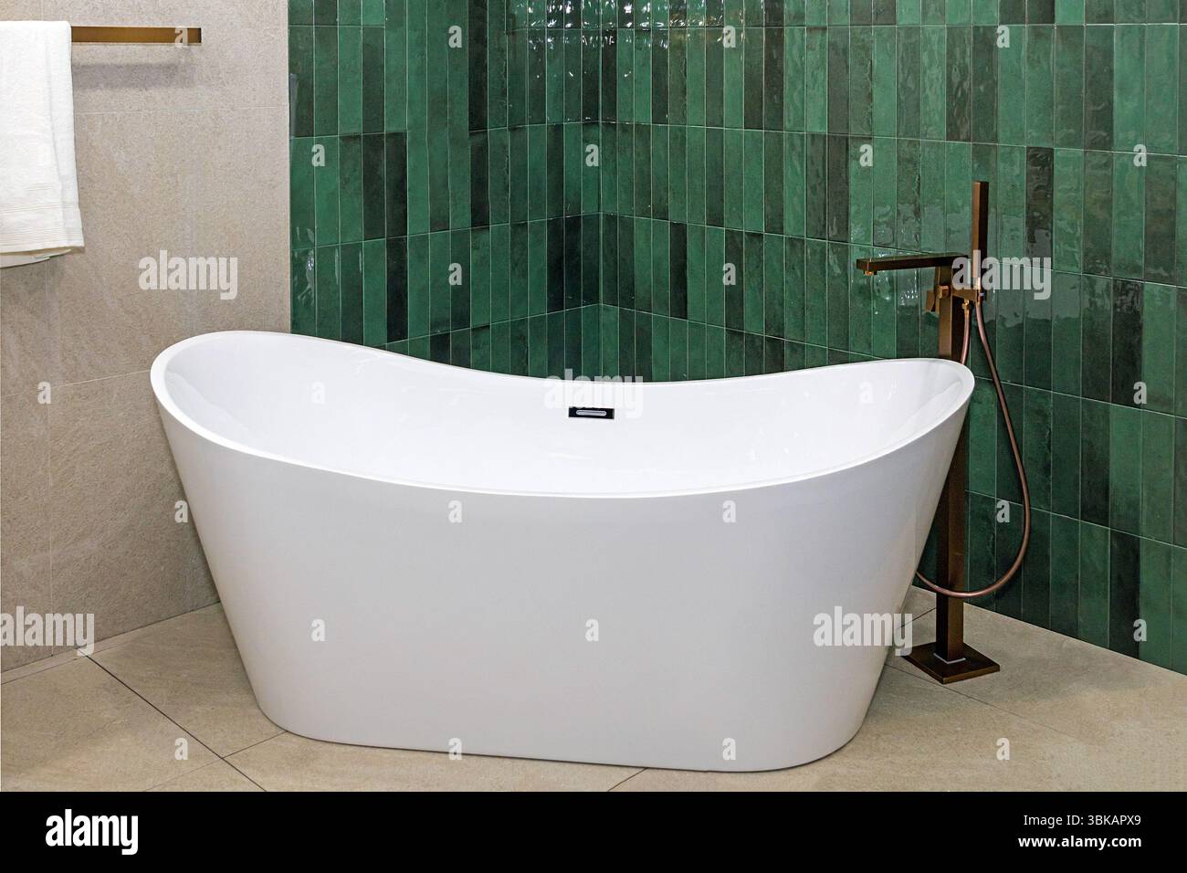 Baignoire en céramique vide à l'intérieur de la salle de bains de luxe avec des carreaux verts Banque D'Images