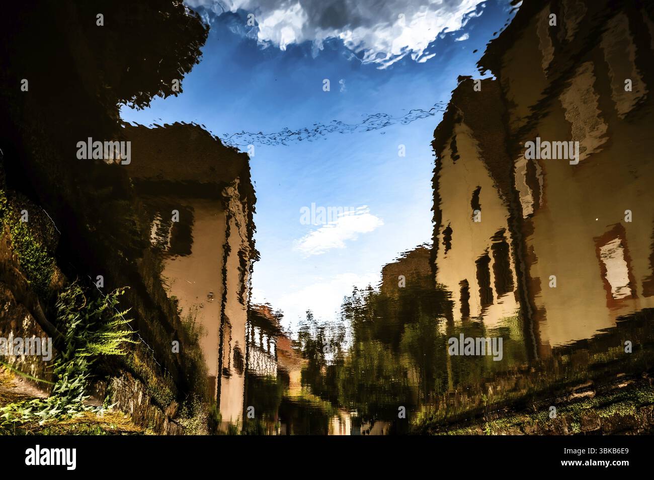 Réflexion des bâtiments dans l'eau, créant une atmosphère mystique par distorsion. Wissembourg. Alsace. France Banque D'Images