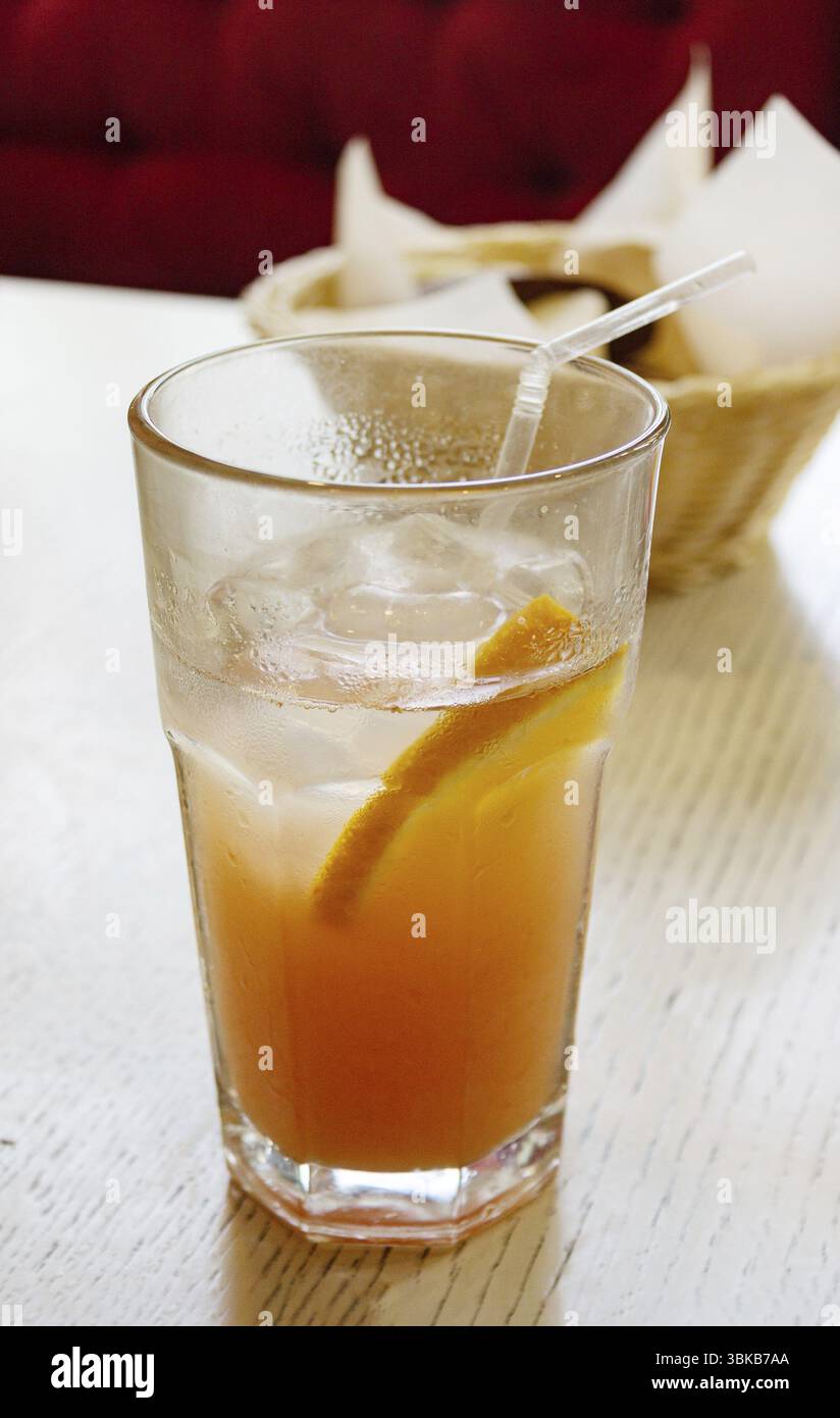 Boire avec de la glace et de l'orange dans un verre, sur la table, dans un café Banque D'Images