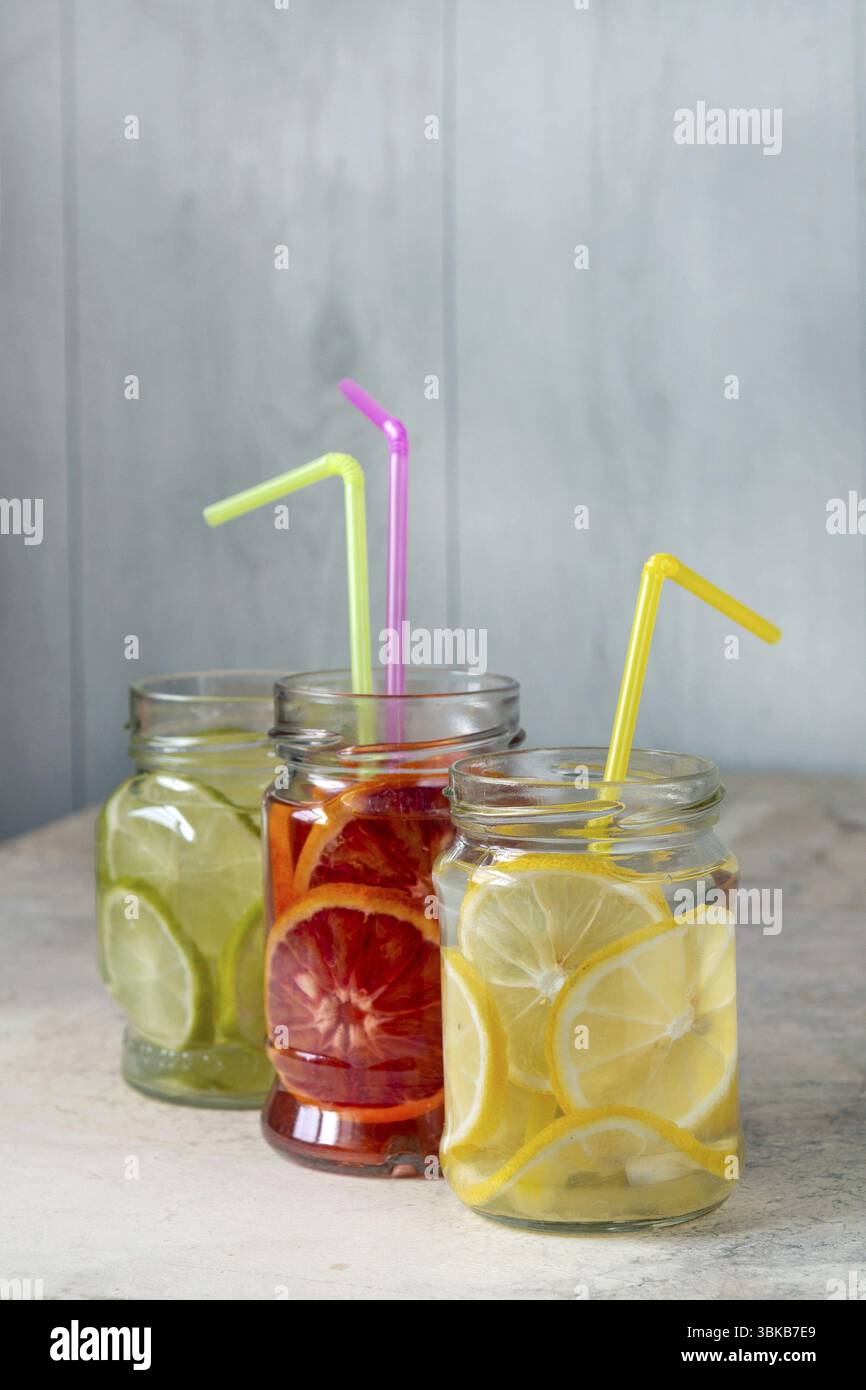 Limonade de citron, citron vert, orange dans des pots en verre sur la table, espace de copie Banque D'Images