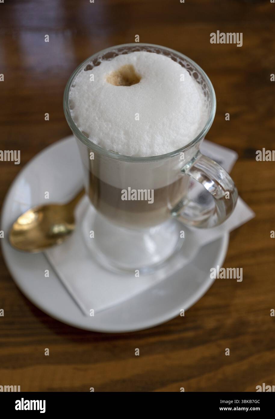 Latte avec haute mousse dans une tasse en verre sur la table, vue de dessus Banque D'Images
