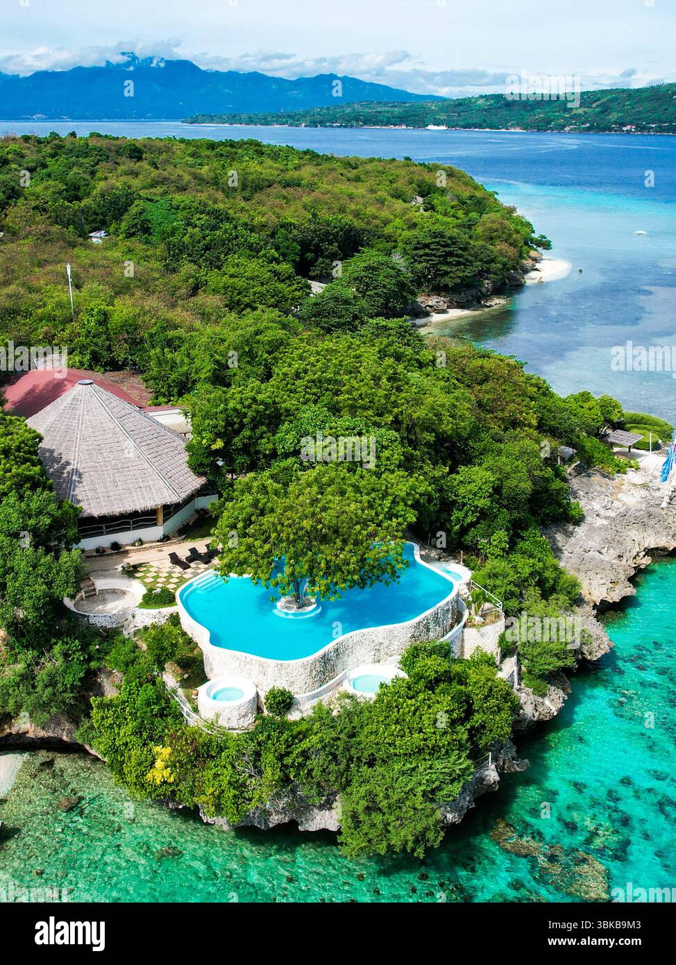 Piscine à débordement, eau turquoise, vue sur l'océan - Une piscine turquoise spectaculaire se mélange avec la mer bleue au-delà, évoquant le luxe pur, la joie et la relaxation profonde Banque D'Images