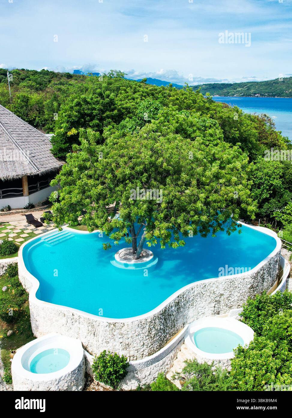 Piscine à débordement, eau turquoise, vue sur l'océan - Une piscine turquoise spectaculaire se mélange avec la mer bleue au-delà, évoquant le luxe pur, la joie et la relaxation profonde Banque D'Images