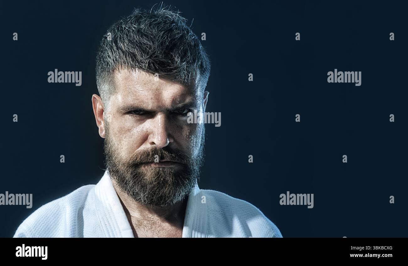 Karaté Man. Combattant de karaté professionnel en kimono exerçant un sport de combat. Combattant masculin de karaté se préparant à la compétition. Modèle de fitness musclé prêt Banque D'Images