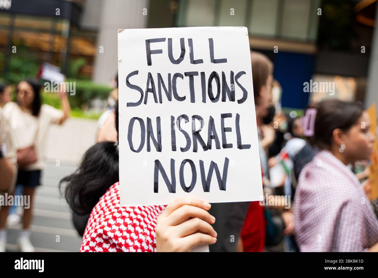 Un manifestant tient une pancarte avec le message « sanctions complètes contre Israël maintenant » pendant la manifestation. Une marche de solidarité pour Gaza a eu lieu à Bangkok. Organisé par la Palestine Solidarity Campaign (PSC), l'événement a rassemblé des manifestants appelant à un cessez-le-feu, à la fin du génocide, de l'apartheid et de l'occupation, et à l'accès de l'aide humanitaire à Gaza. Les participants portaient des drapeaux palestiniens et des pancartes avec divers messages de soutien. Banque D'Images