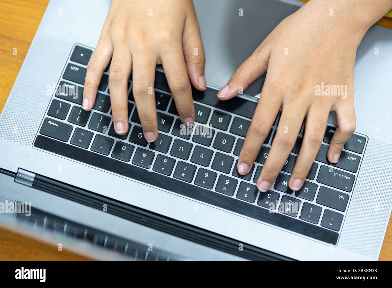 Gros plan des mains d'un étudiant ou d'un professionnel tapant sur un ordinateur portable, travaillant sur un devoir, écrivant un e-mail, naviguant sur Internet ou codin Banque D'Images