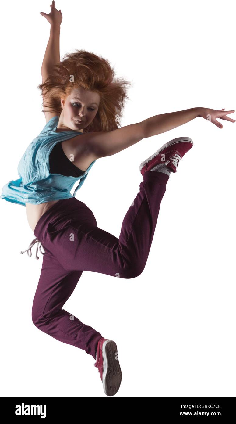 Danseuse féminine saute en plein air dans un design plat avec fond blanc, top turquoise et baskets rouges Banque D'Images