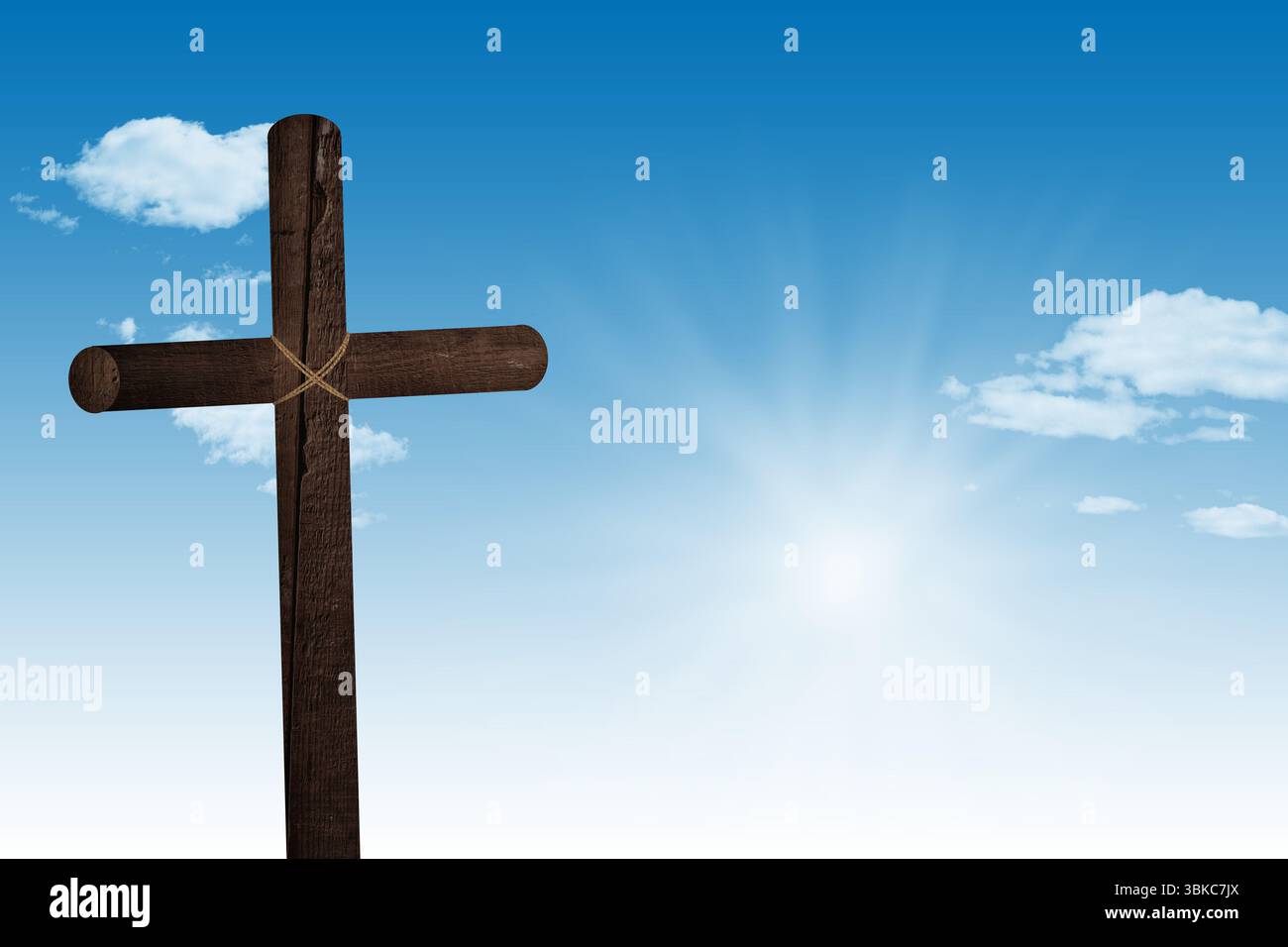 La croix en bois de conception plate se tient contre un ciel bleu vif avec des rafales de soleil et des nuages dispersés Banque D'Images