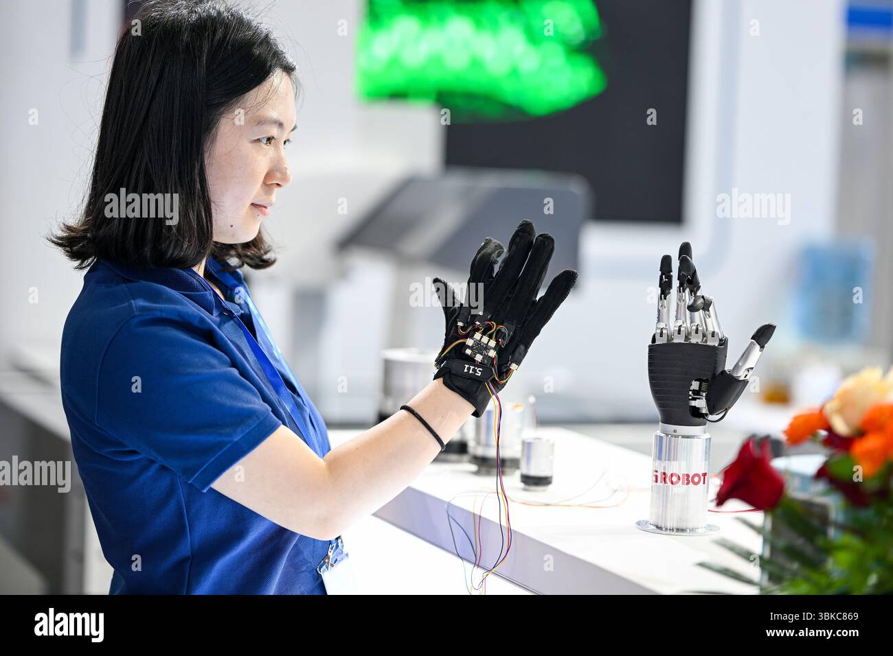NANJING, CHINE - 20 JUIN 2025 - Un membre du personnel a commandé à distance un bras mécanique bionique de manière synchrone à l'aide de gants à détection de force lors de l'exposition universelle des semi-conducteurs 2025 à Nanjing, province du Jiangsu, Chine, le 20 juin 2025. Banque D'Images