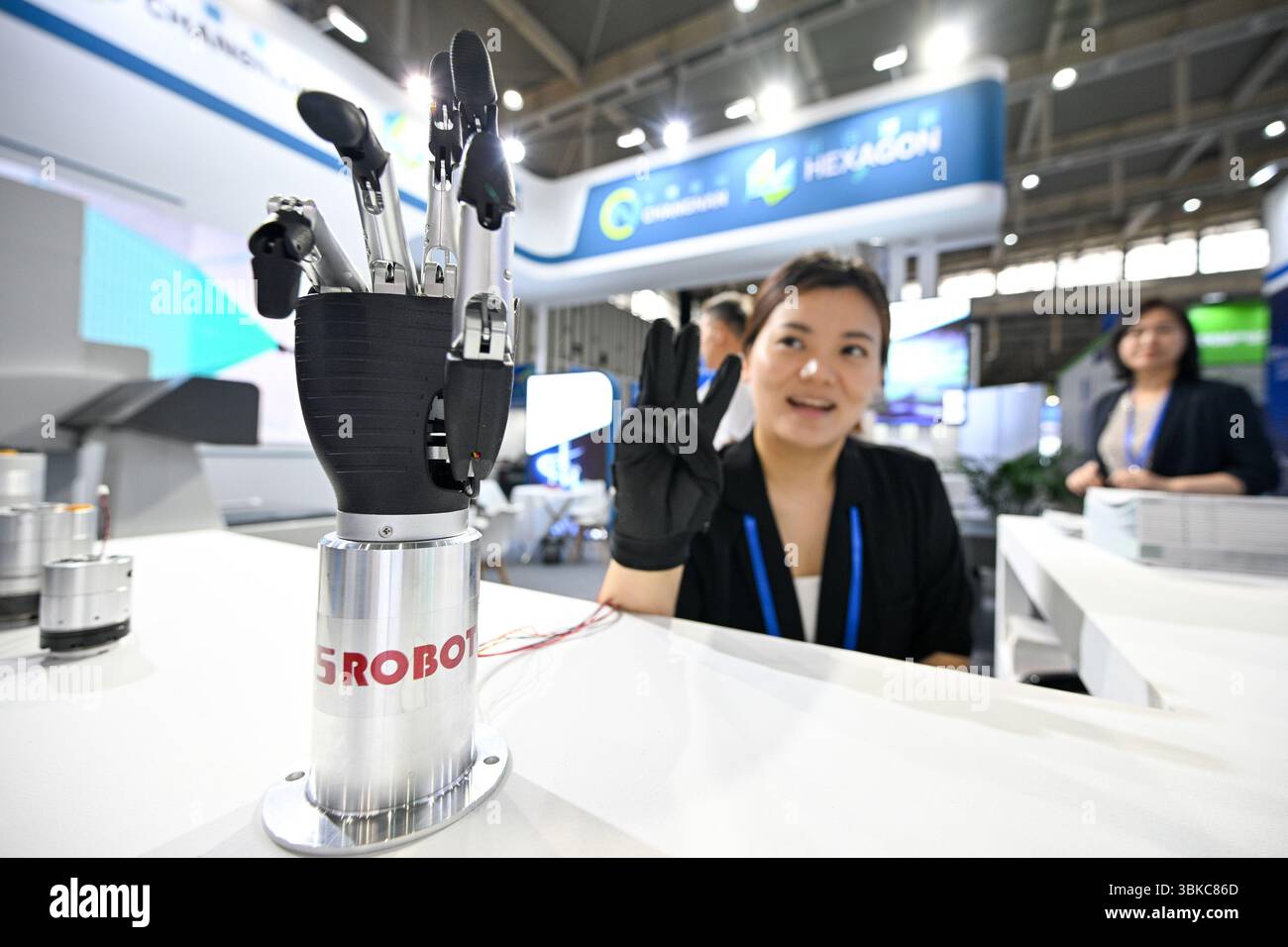 NANJING, CHINE - 20 JUIN 2025 - Un membre du personnel a commandé à distance un bras mécanique bionique de manière synchrone à l'aide de gants à détection de force lors de l'exposition universelle des semi-conducteurs 2025 à Nanjing, province du Jiangsu, Chine, le 20 juin 2025. Banque D'Images