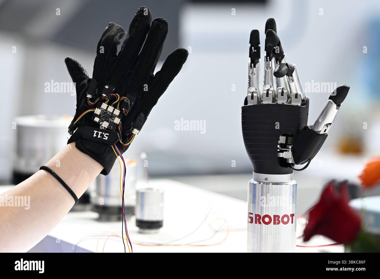 NANJING, CHINE - 20 JUIN 2025 - Un membre du personnel a commandé à distance un bras mécanique bionique de manière synchrone à l'aide de gants à détection de force lors de l'exposition universelle des semi-conducteurs 2025 à Nanjing, province du Jiangsu, Chine, le 20 juin 2025. Banque D'Images