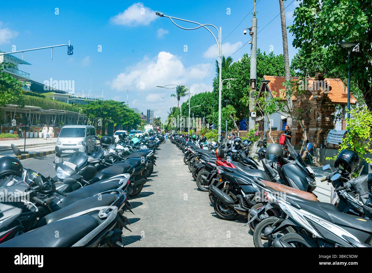 Une rangée de motos et de scooters garés dans une rue à Denpasar, Bali, Indonésie Banque D'Images