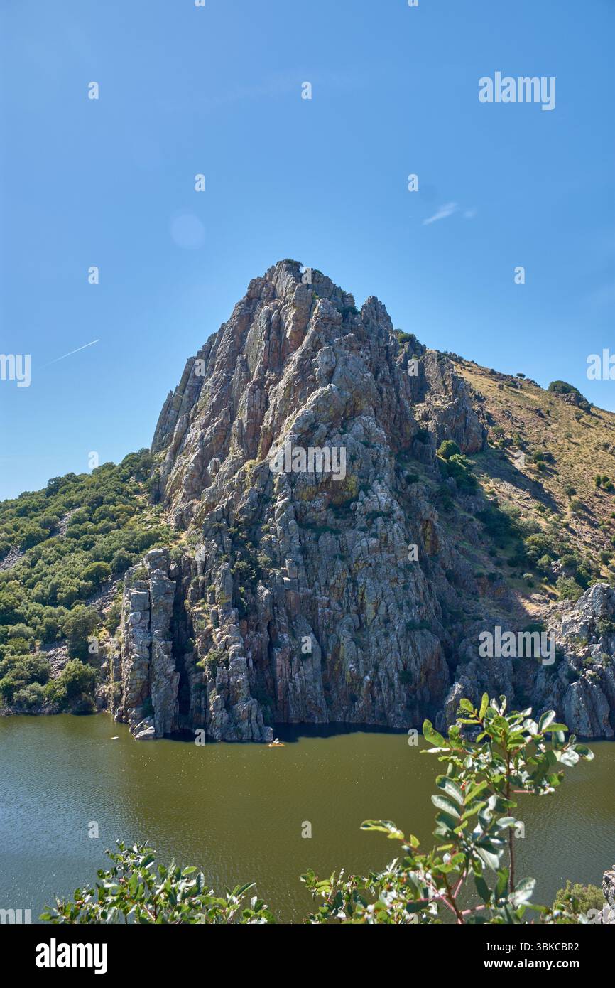 D'impressionnantes formations rocheuses, connues sous le nom de Salto del Gitano, s'élèvent majestueusement des eaux d'une rivière, probablement le Tage, dans le Monfrague National par Banque D'Images