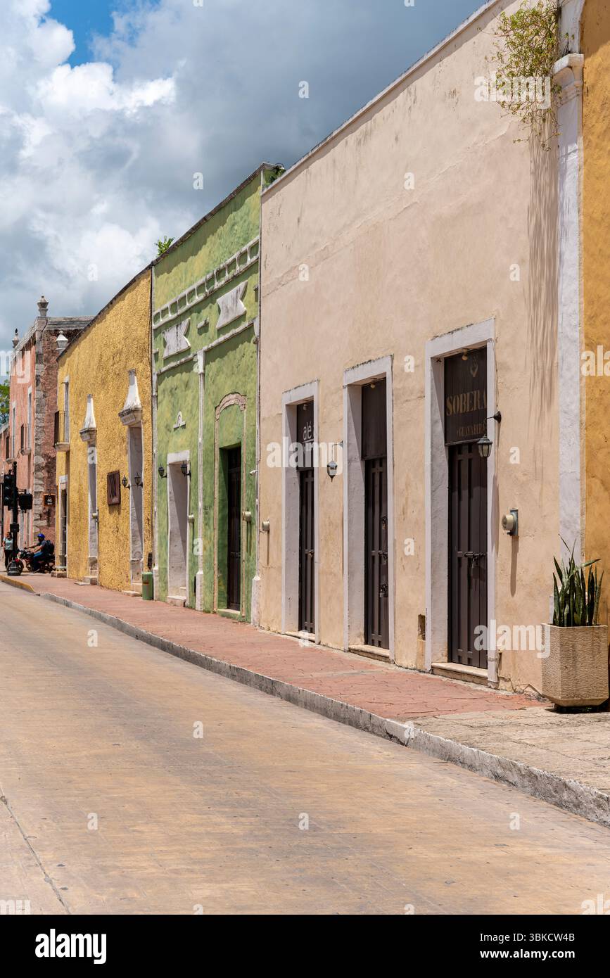 Bâtiments coloniaux jaunes et verts à l'architecture traditionnelle sur une rue étroite au Mexique, péninsule du Yucatan, Valladolid. Banque D'Images
