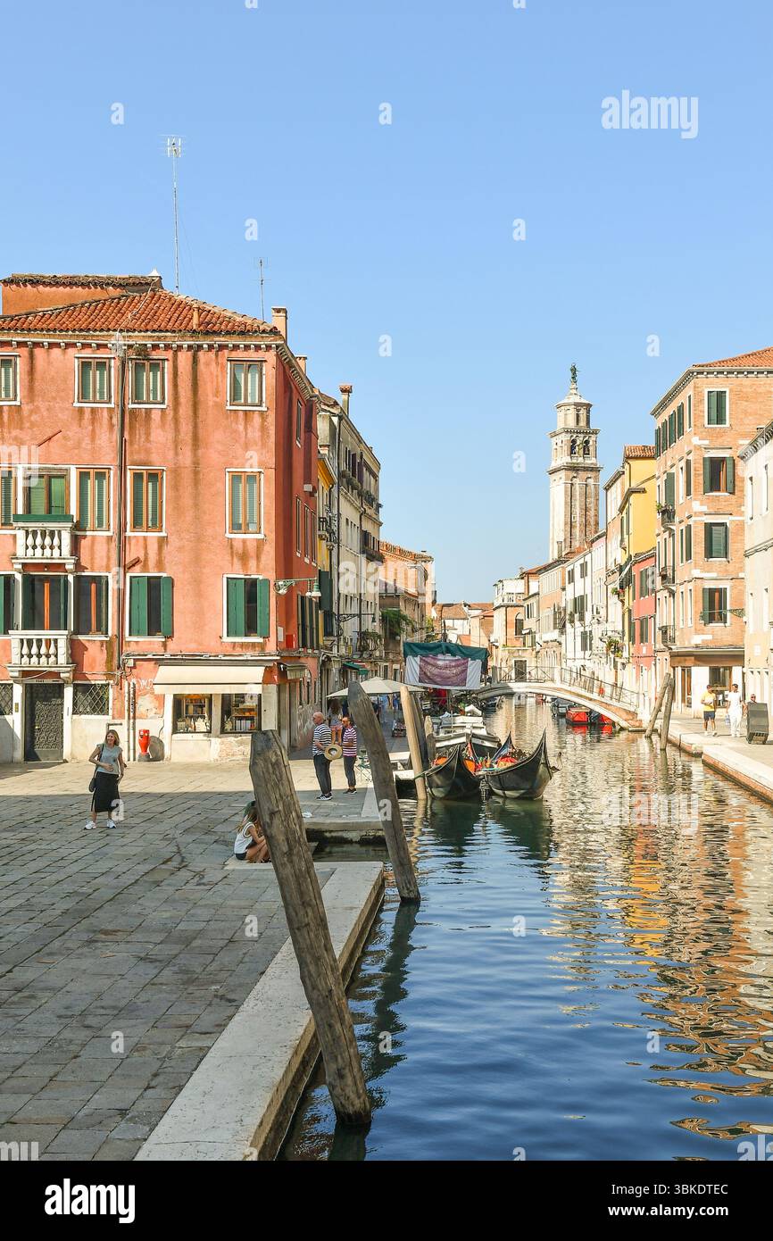 Vue depuis Campo San Barnaba avec gondoles sur le canal Rio de San Barnaba, pont Ponte dei Pugni et tour de l'église Santa Maria dei Carmini, Venise Banque D'Images