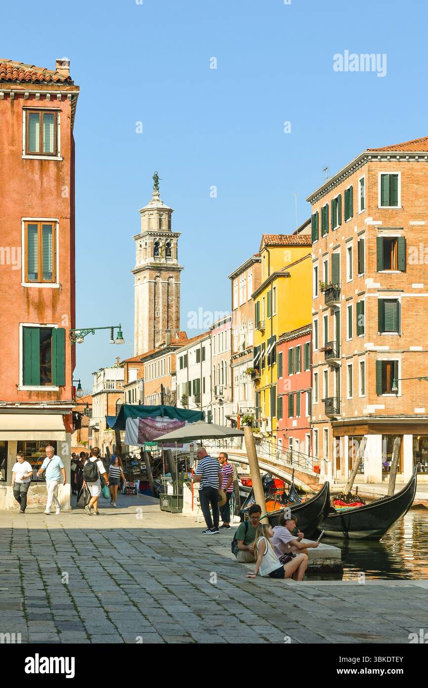 Vue depuis Campo San Barnaba avec gondoles sur le canal Rio de San Barnaba, pont Ponte dei Pugni et tour de l'église Santa Maria dei Carmini, Venise Banque D'Images