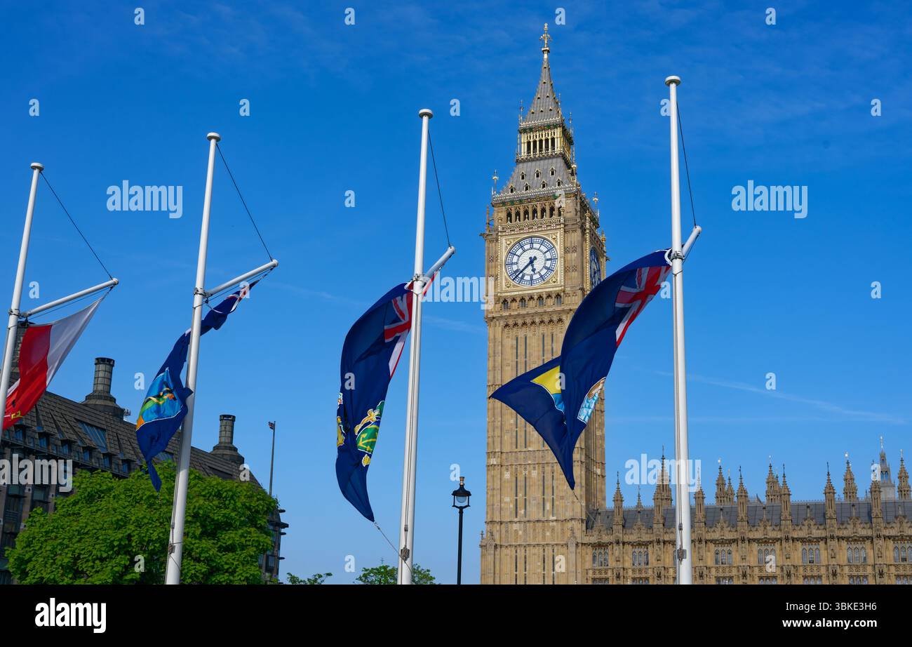 Drapeaux flottant sur la place du Parlement avec Big Ben et les chambres du Parlement un jour de ciel bleu ensoleillé, Londres Banque D'Images
