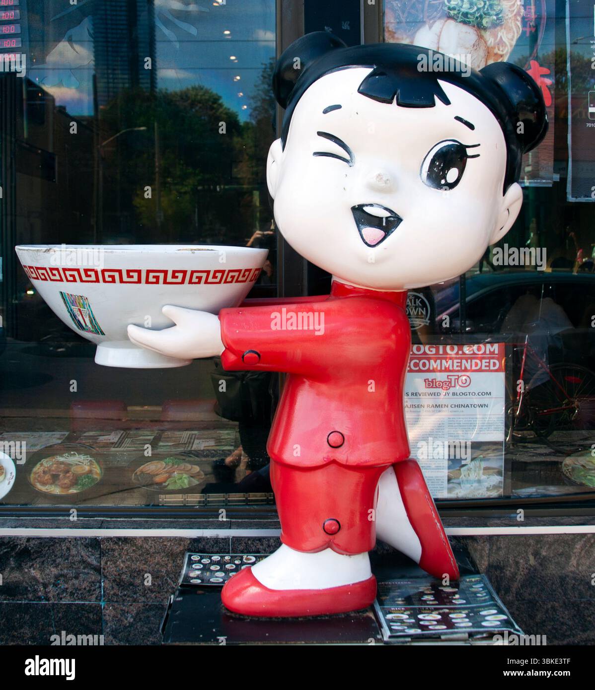 Statue de bol de nouilles claquant devant un restaurant chinois à Toronto—une mascotte ludique et colorée dessinant des visiteurs affamés. Banque D'Images