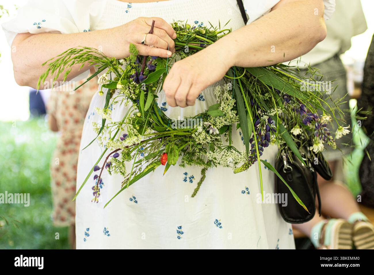 Fabrication de couronnes de nuit de milieu d'été avec des plantes, des feuilles et des fleurs Banque D'Images