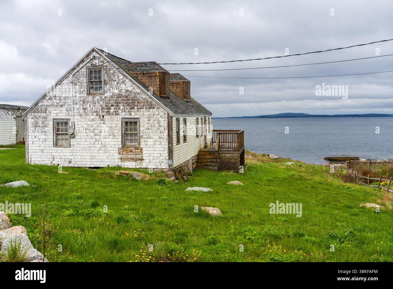 La maison solitaire nécessitant des rénovations surplombe le port de Peggys Cove, près de Halifax, en Nouvelle-Écosse, au Canada Banque D'Images