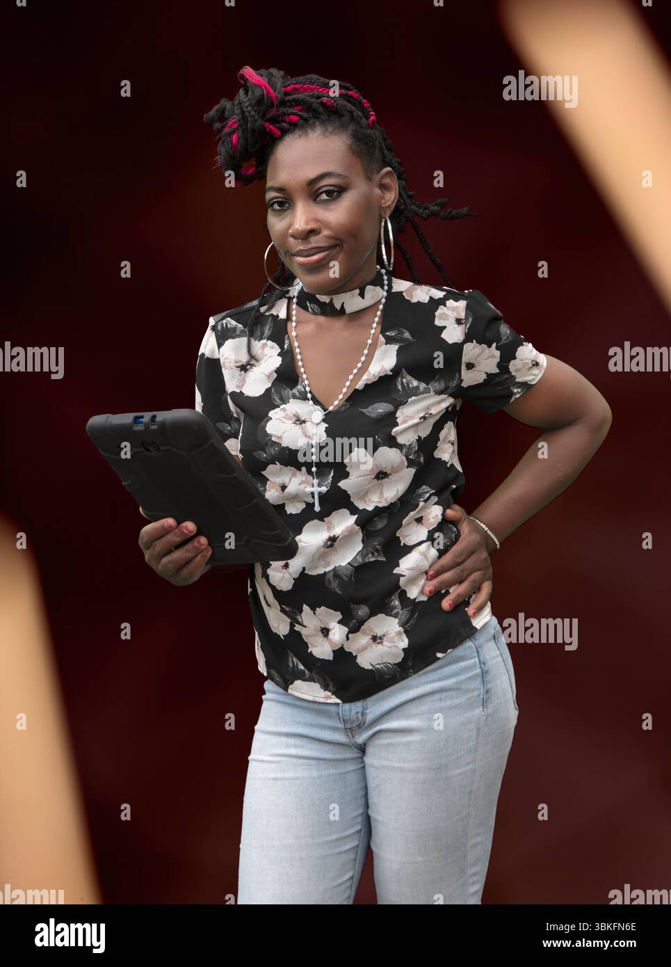 Femme à la mode avec coiffure protectrice à l'aide d'un téléphone portable, parfait pour la technologie et les concepts de style de vie Banque D'Images