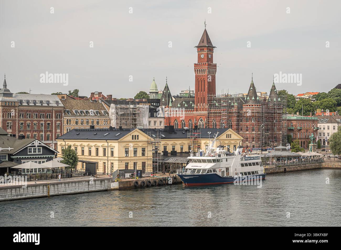 Ferry amarré au port de Helsingborg, Suède, avec l'emblématique hôtel de ville en briques rouges et les bâtiments historiques du front de mer en vue, Suède, le 15 juin 202 Banque D'Images