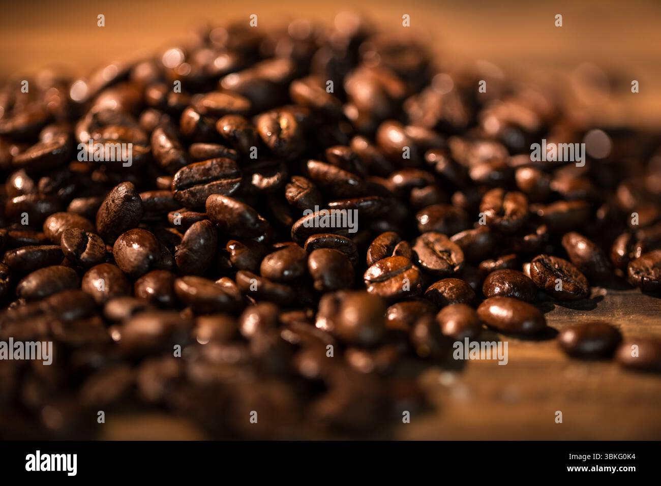 Les grains de café torréfiés brillants brillent sur le dessus de table en bois chaud dans un design plat Banque D'Images
