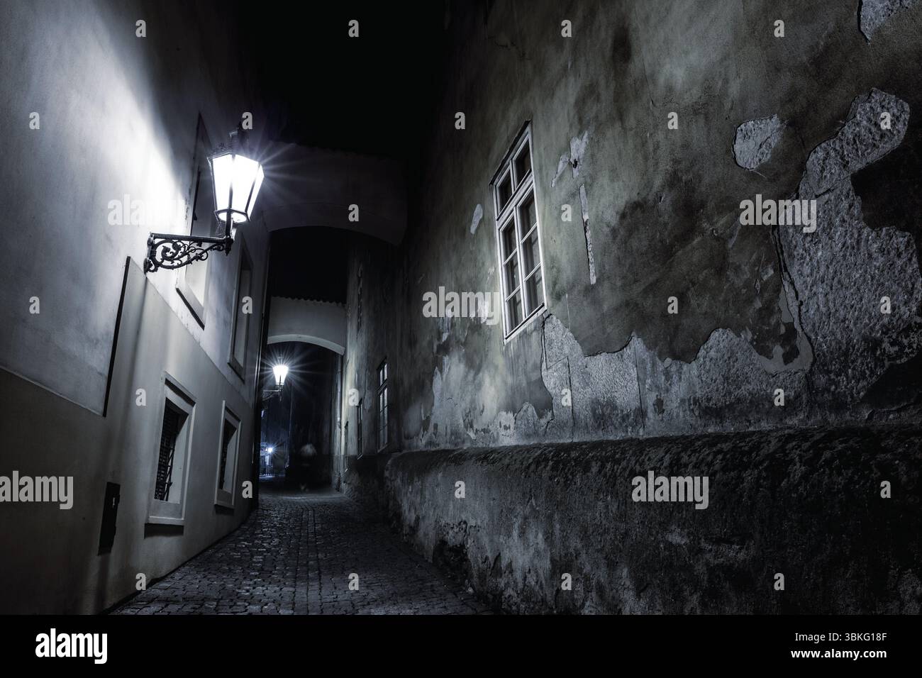 Conception plate montrant l'allée pavée étroite sous l'arche la nuit avec des lampes éclairant le passage Banque D'Images