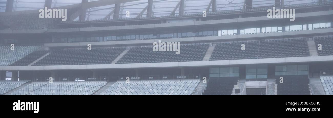 Les niveaux de sièges de stade de conception plate montrent des rangées vides avec des garde-corps et un toit en treillis en acier Banque D'Images