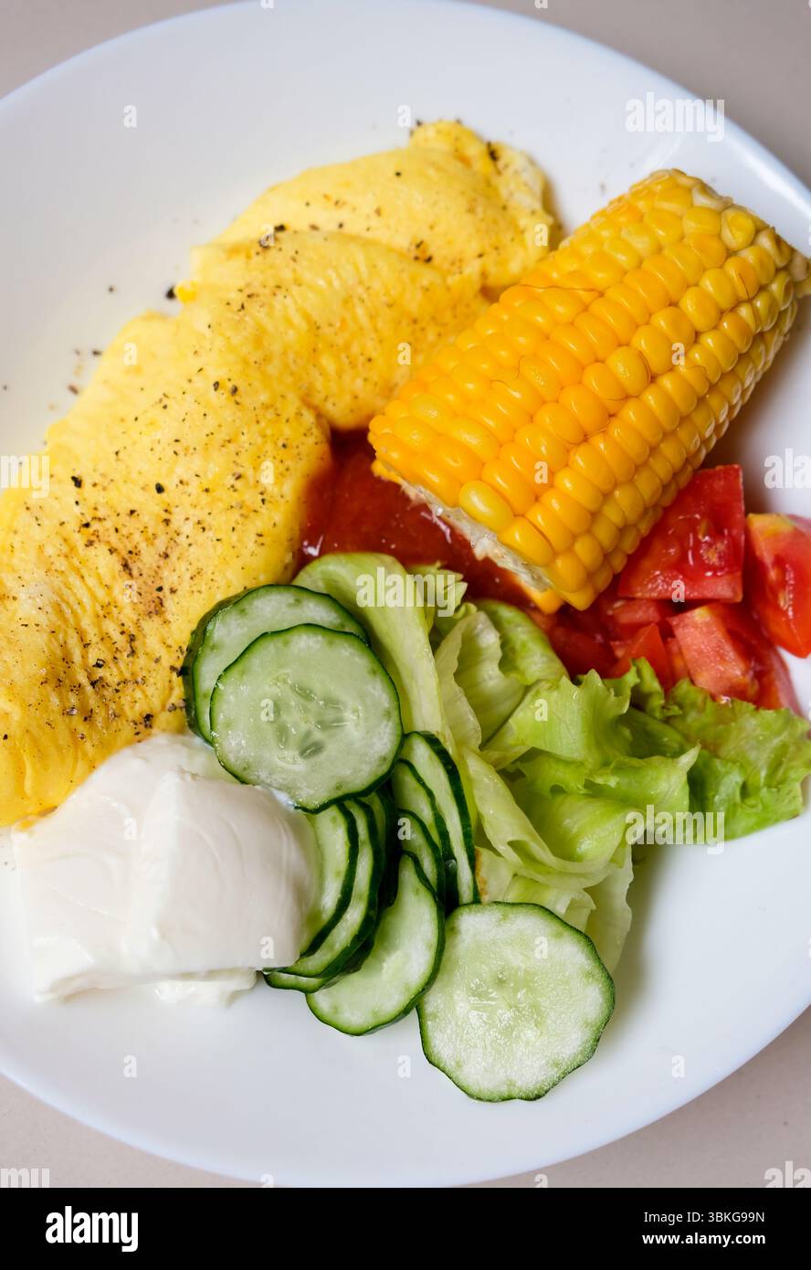 Assiette de petit-déjeuner nutritive saine avec omelette, mélange de légumes et de yaourt le matin Banque D'Images